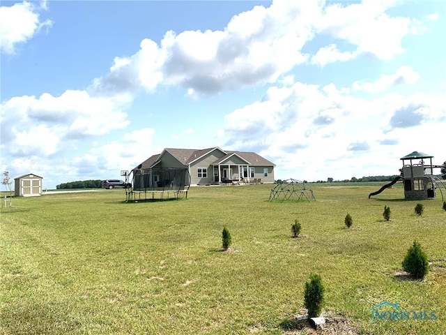 view of yard with a trampoline, an outbuilding, a playground, and a storage shed