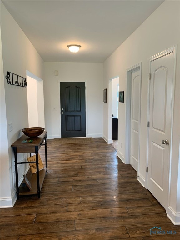 entryway featuring dark wood-type flooring and baseboards