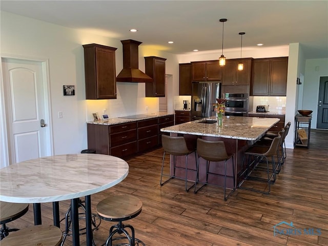 kitchen featuring wall chimney range hood, dark wood-type flooring, dark brown cabinetry, and stainless steel fridge with ice dispenser