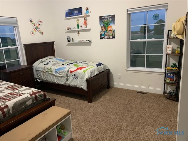 carpeted bedroom with visible vents and baseboards