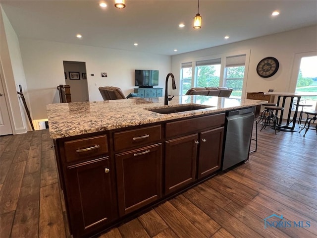 kitchen with dark wood-type flooring, a sink, dishwasher, and light stone countertops