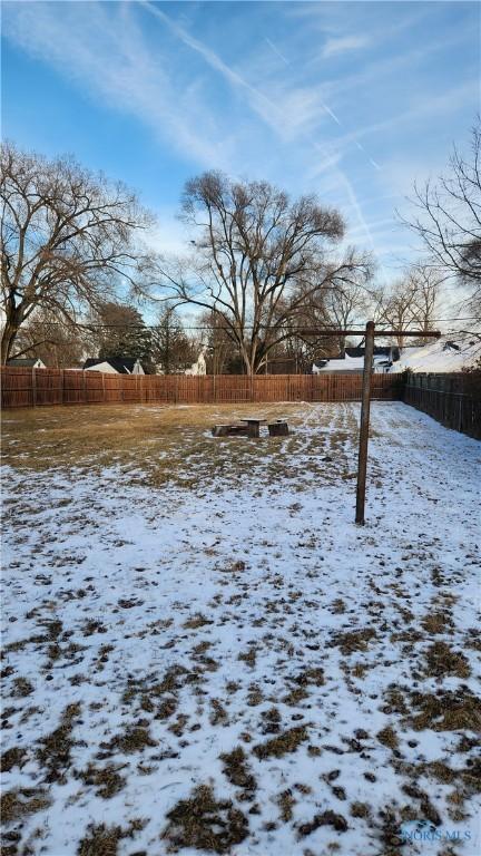 yard layered in snow with fence