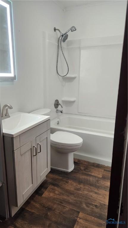 bathroom with vanity, bathing tub / shower combination, wood finished floors, and toilet