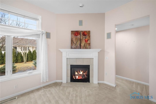 unfurnished living room featuring a fireplace, carpet flooring, visible vents, and baseboards