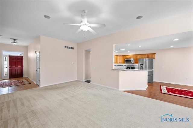 unfurnished living room featuring light carpet, baseboards, visible vents, and recessed lighting