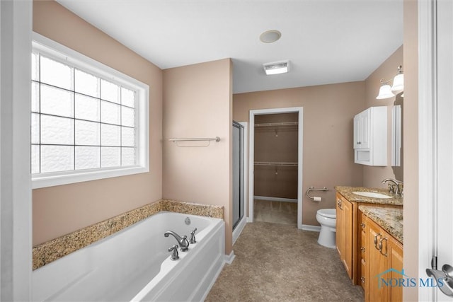 bathroom featuring toilet, vanity, a shower stall, baseboards, and a bath