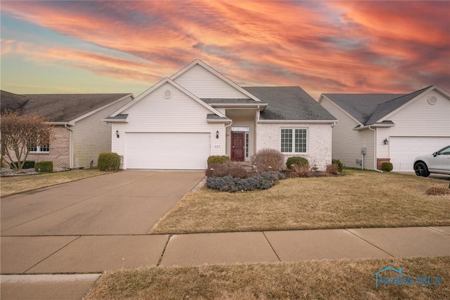 view of front of home featuring driveway, a garage, and a front lawn