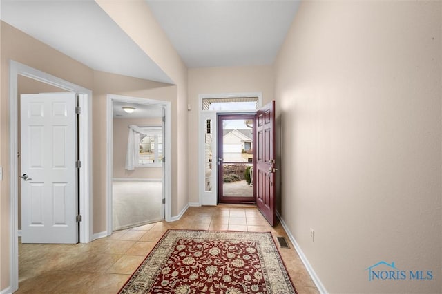 entryway featuring light tile patterned floors, baseboards, and visible vents