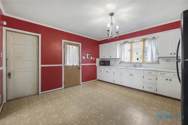 kitchen with light countertops, white cabinets, and a notable chandelier