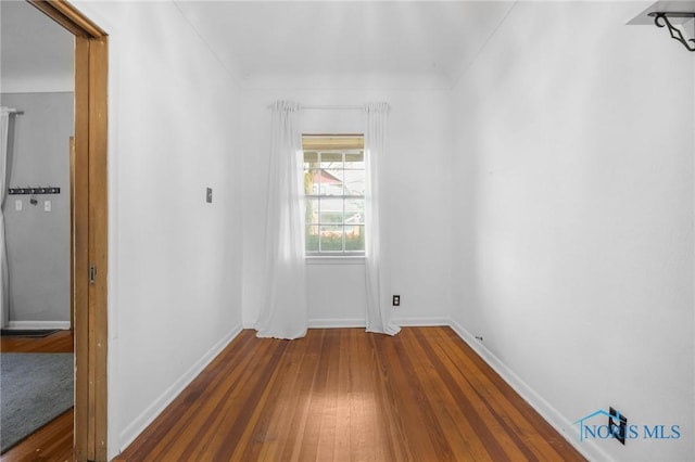 empty room featuring baseboards and wood finished floors