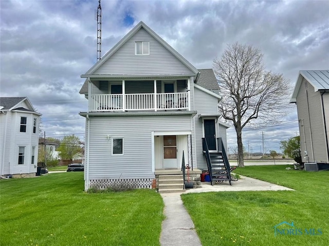 view of front of home featuring a balcony and a front lawn