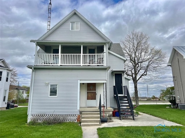 view of front of house with a front yard and a balcony