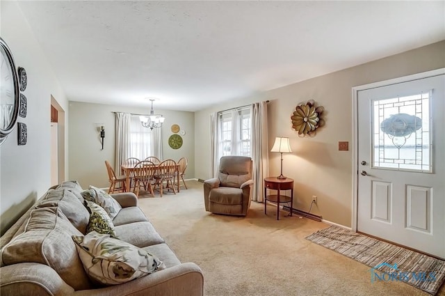 carpeted living area featuring a chandelier and baseboards