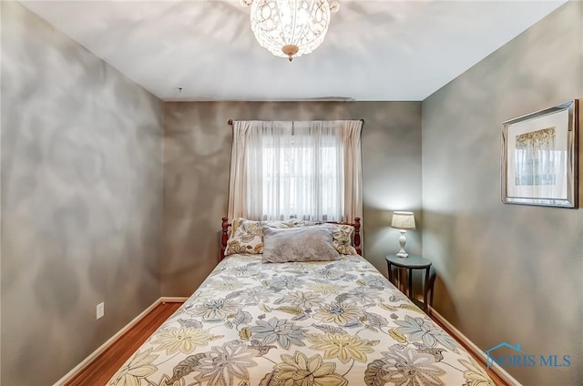 bedroom featuring wood finished floors and baseboards