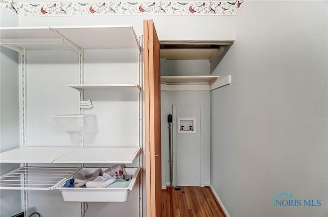 washroom with baseboards, laundry area, wood finished floors, and hookup for a washing machine