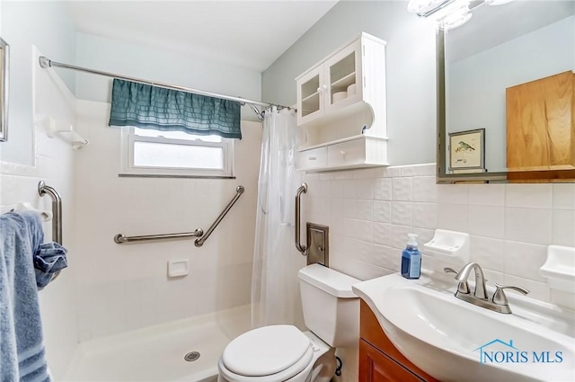 bathroom with tile walls, vanity, toilet, and a shower with curtain