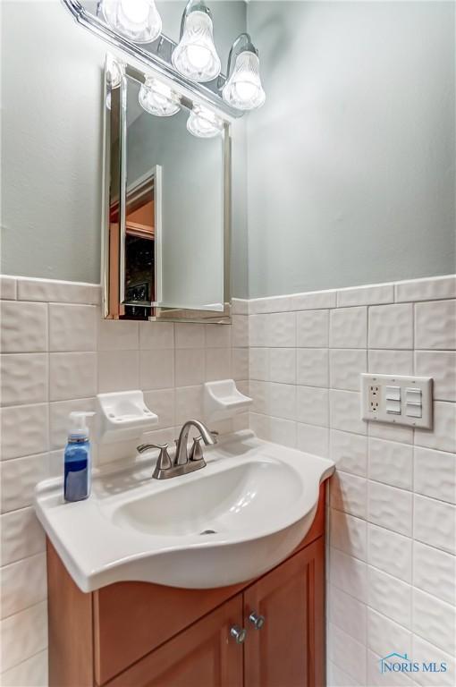 bathroom featuring vanity and tile walls