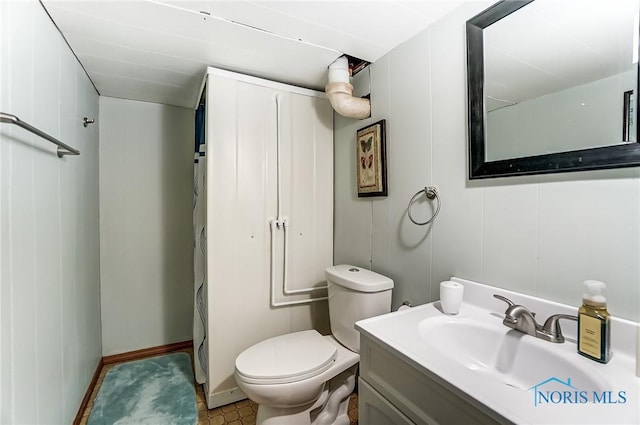 full bath with curtained shower, vanity, and toilet