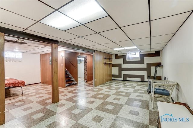 basement with stairway and a drop ceiling