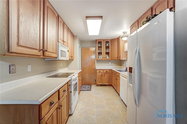 kitchen with light countertops, white appliances, a sink, and glass insert cabinets