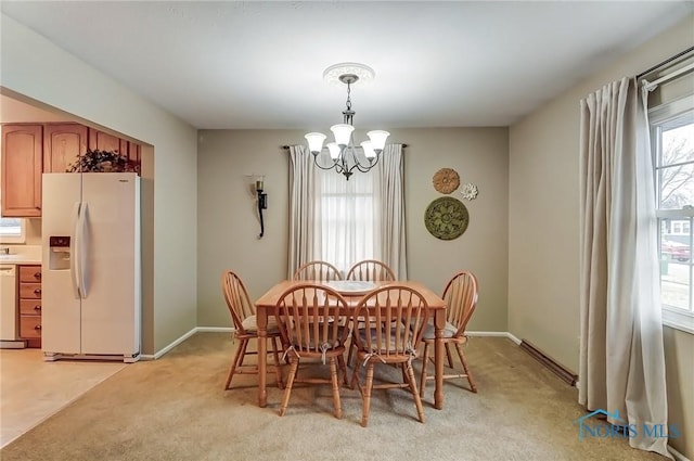 dining room with baseboards, light colored carpet, and a notable chandelier