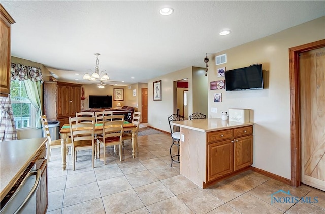 kitchen with baseboards, visible vents, dishwashing machine, open floor plan, and light countertops