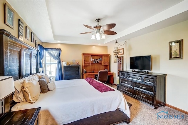 bedroom with ceiling fan, a raised ceiling, light colored carpet, and baseboards