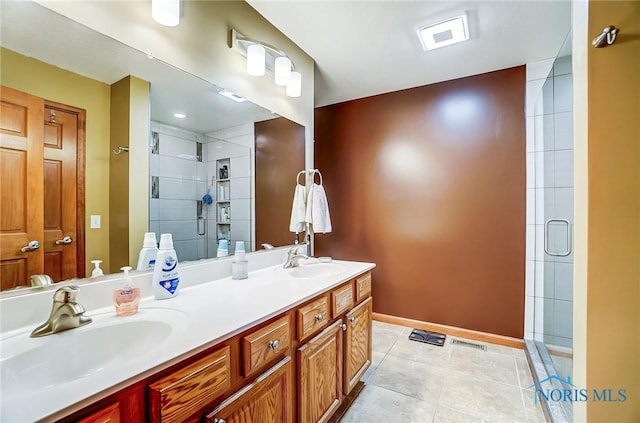 bathroom featuring baseboards, tile patterned flooring, a sink, and a shower stall