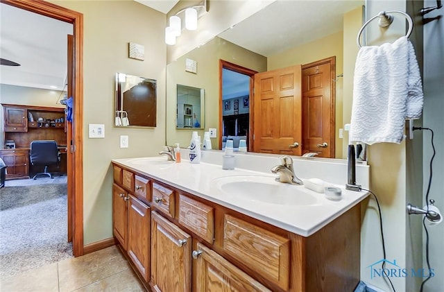 full bath with tile patterned flooring, a sink, baseboards, and double vanity