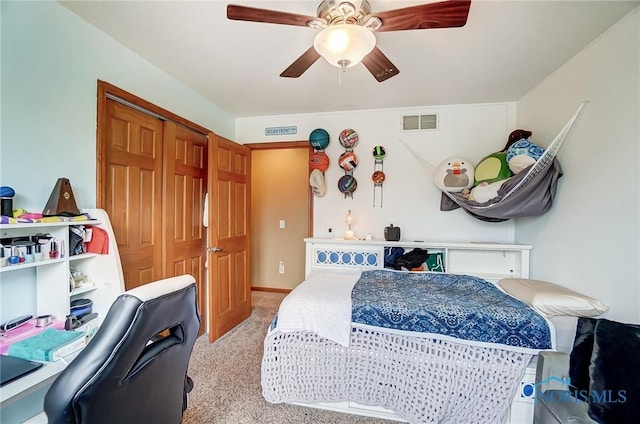 bedroom with a ceiling fan, visible vents, a closet, and light colored carpet