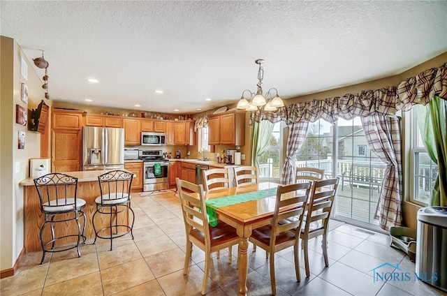 dining area featuring a textured ceiling, recessed lighting, light tile patterned flooring, and a notable chandelier