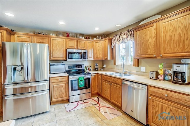 kitchen featuring light tile patterned floors, stainless steel appliances, light countertops, a sink, and recessed lighting