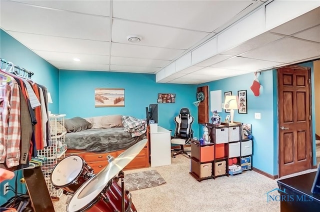 bedroom featuring a drop ceiling and carpet flooring