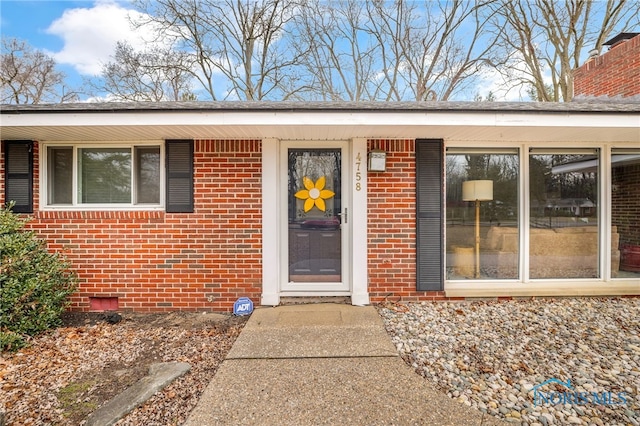 entrance to property with crawl space and brick siding