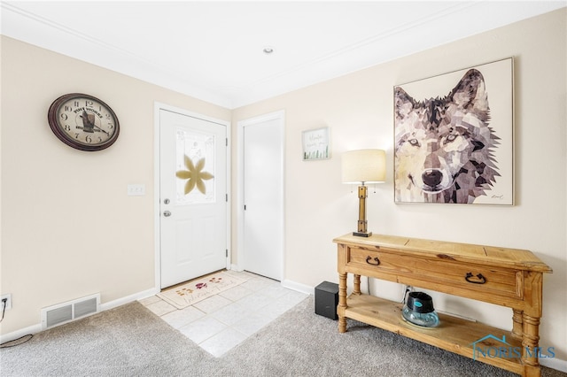 carpeted foyer entrance with visible vents and baseboards