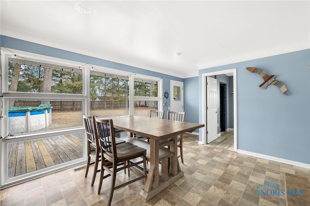 dining space with stone finish floor and baseboards