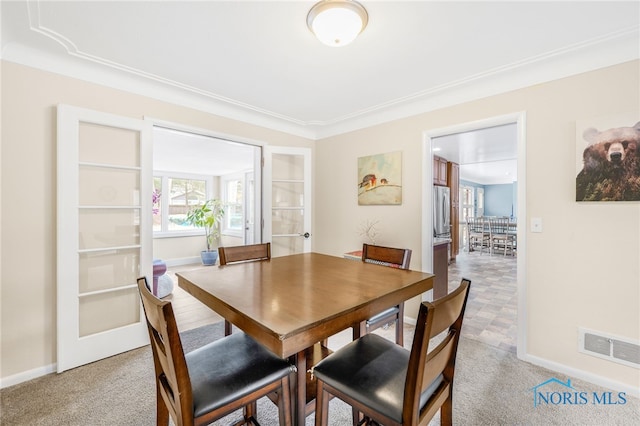 dining area with light carpet, visible vents, and baseboards