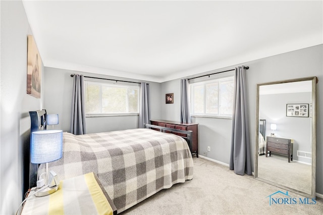 carpeted bedroom featuring multiple windows, visible vents, and baseboards