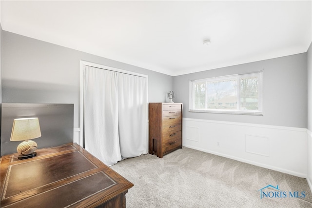 carpeted home office with a wainscoted wall