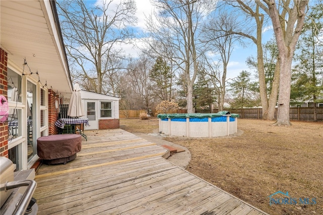 wooden deck featuring a fenced in pool and a fenced backyard