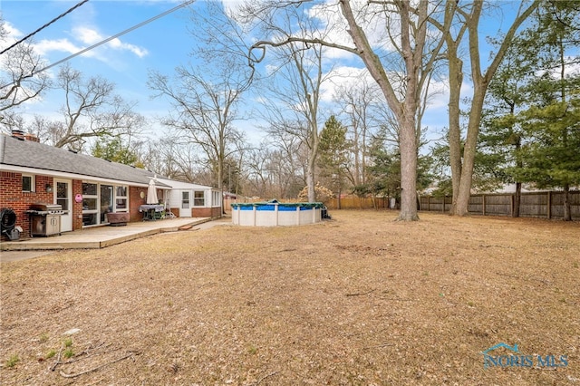 view of yard featuring a patio area, fence, and a fenced in pool