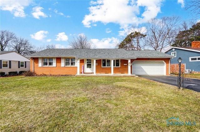 ranch-style home featuring brick siding, a porch, a garage, driveway, and a front lawn