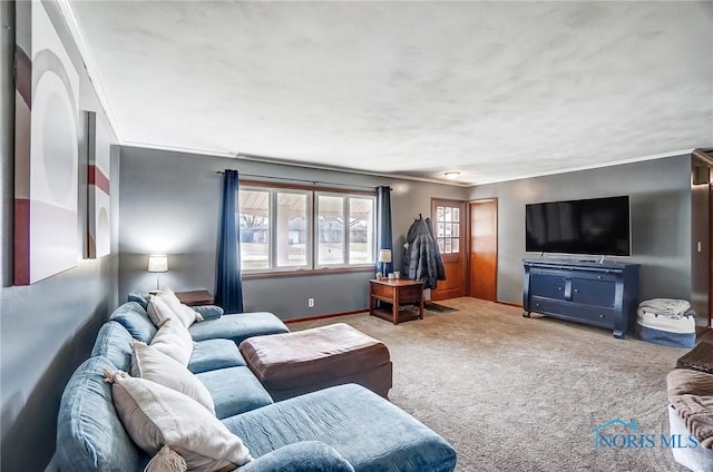 carpeted living room featuring ornamental molding and baseboards