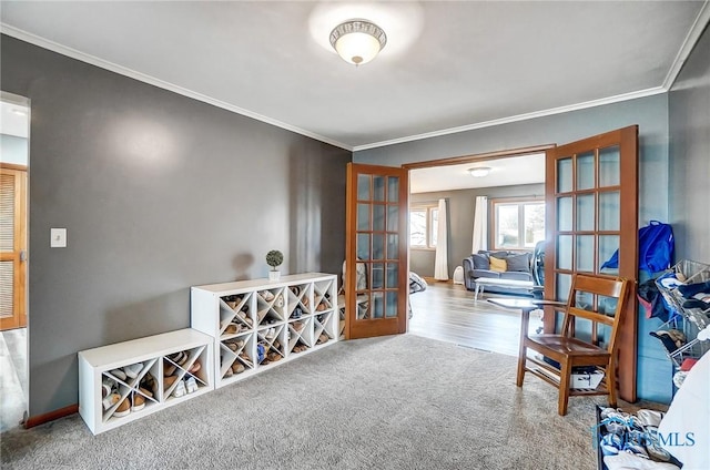 interior space with carpet floors, french doors, crown molding, and baseboards