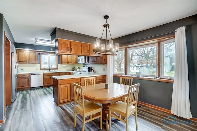 dining room with an inviting chandelier, baseboards, and dark wood-type flooring