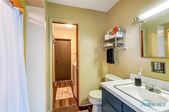 bathroom featuring vanity, toilet, and wood finished floors