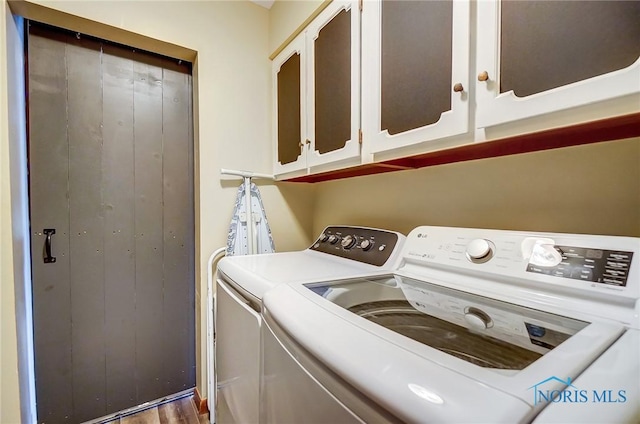 clothes washing area with washer and dryer and cabinet space