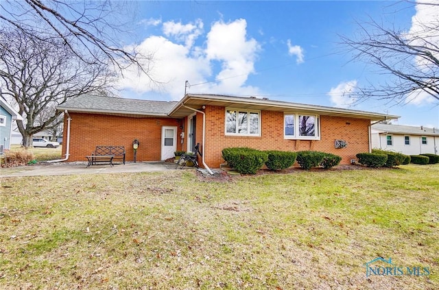 view of front of house featuring a front lawn and brick siding