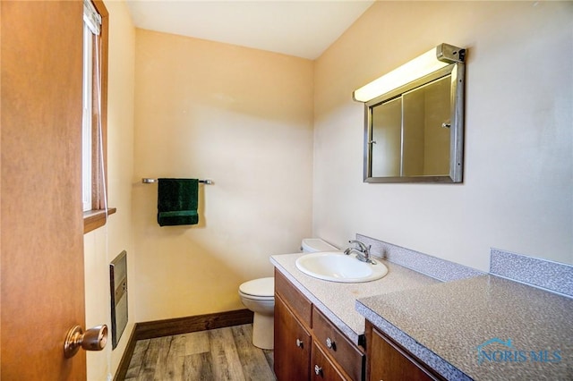 bathroom featuring vanity, wood finished floors, toilet, and baseboards