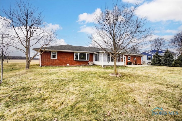 ranch-style house with a sunroom, a front lawn, and brick siding